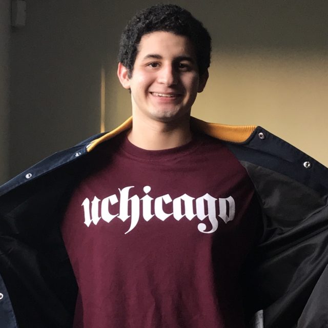 Justin Funez smiles while showing off his uchicago shirt