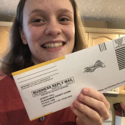 A volunteer holds up a mail in ballot