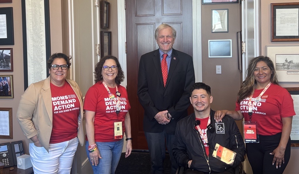Four California volunteers pose for a photo with Rep. Mark DeSaulnier. Two volunteers pose on either side of him. All the volunteers wear red Moms Demand Action t-shirts. Rep. DeSaulnier wears a black suit jacket, red tie, and blue shirt. 